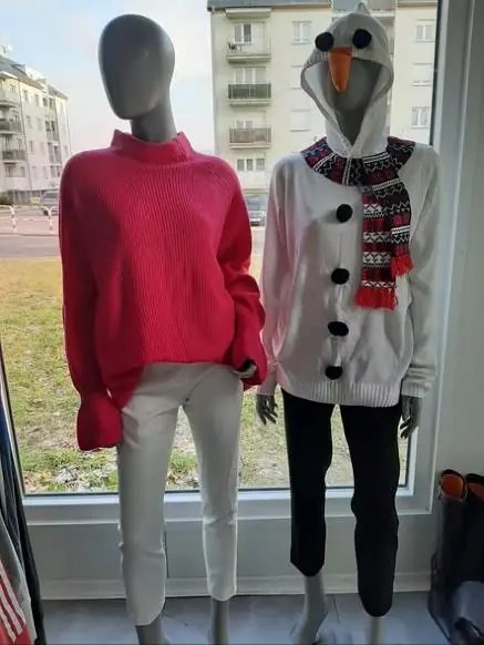 Czerwony sweter i świąteczna bluza z bałwankiem na manekinach