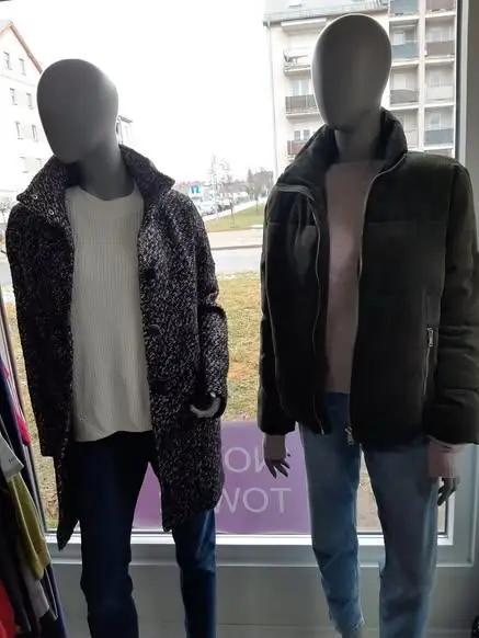 Zimowe płaszcze na manekinach w oknie sklepu