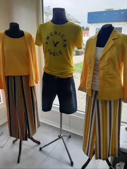 Żółte zestawy na manekinach: sweter, koszulka i żakiet